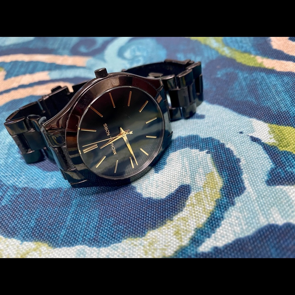 Black Michael Kors watch with gold accents.